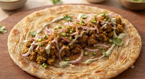 Garam Shami Kabab Paratha Roll par maslay hue Shami Kabab, pyaz, hari mirch aur chaat masala ki filling dikhai gayi hai.